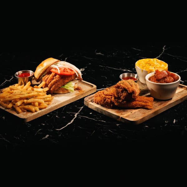 The L Station's fried fish sandwich with fries, and a fried fish platter with mac and cheese and candied yams.