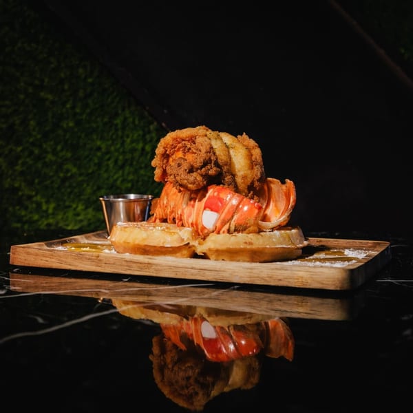 The L Station's lobster and fried chicken on waffles with syrup and powdered sugar.